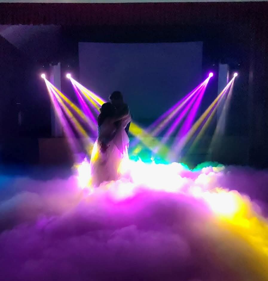 Couple dansant dans la fumée avec jeux de lumières